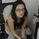 An attractive brunette girl wearing glasses takes a shit while sitting on a toilet after her workout. Sweat is still visible on her pants. Audible poop sounds. She sniffs her toilet paper after wiping. Presented in 720P HD. About 3.5 minutes.